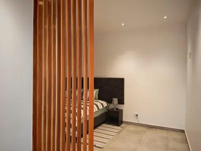 a bedroom with a bed and a wooden partition at Kubata Diame B&B in Cape Town