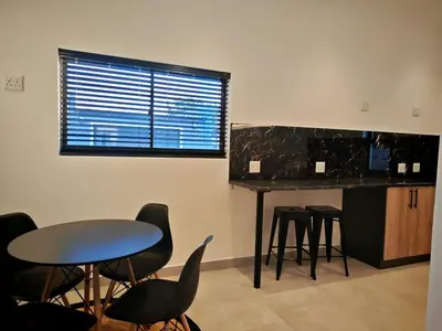 a room with a table and chairs and a counter at Kubata Diame B&B in Cape Town