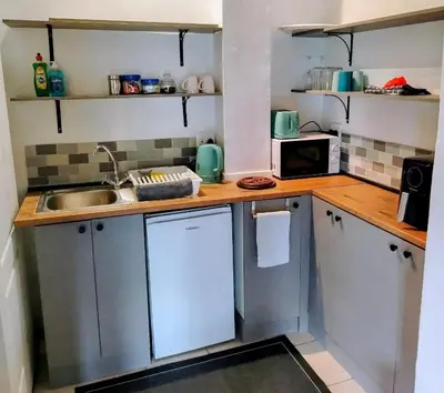 a small kitchen with a sink and a microwave at The Thatched Cottage in Eversdal