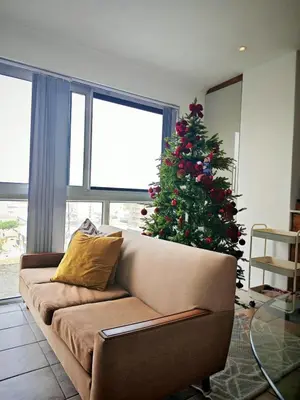 a christmas tree in a living room with a couch at Comfy 1 Bedroom Flat in Thornton
