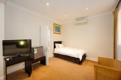 a hotel room with a bed and a television at Cumberland Hotel & Conference Centre Worcester in Worcester