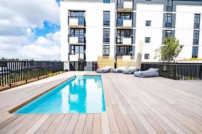 a swimming pool on a deck in front of a building at 622 Riverlands - Lux 2 Bedroom Apartment in Cape Town