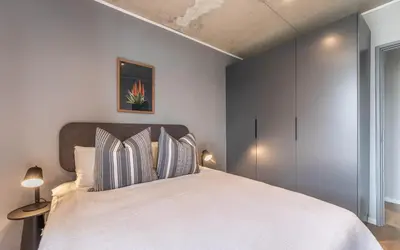 a bedroom with a large white bed with two pillows at 622 Riverlands - Lux 2 Bedroom Apartment in Cape Town