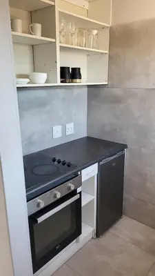 a kitchen with a stove and a counter top at Frankie's Nest in Cape Town