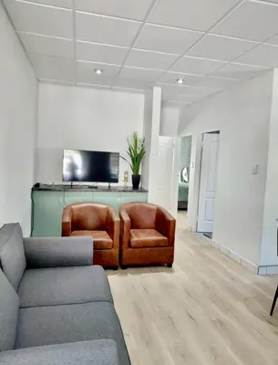a living room with two chairs and a couch at Finch Nest Self Catering in Paarl