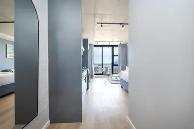 a room with a bed and a room with a mirror at 805 Riverlands - Lux Studio Apartment in Cape Town