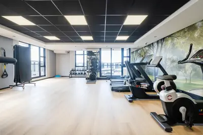 a gym with treadmills and exercise equipment and a mural at 805 Riverlands - Lux Studio Apartment in Cape Town