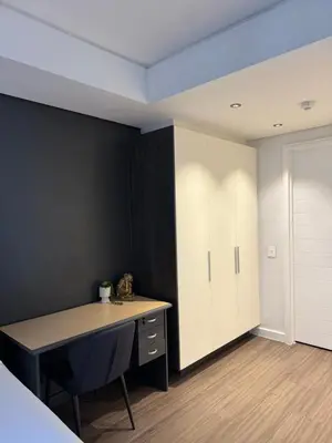 a bedroom with a desk and a cabinet in a room at Enzo Stay -The Matrix 505 , Century City in Cape Town