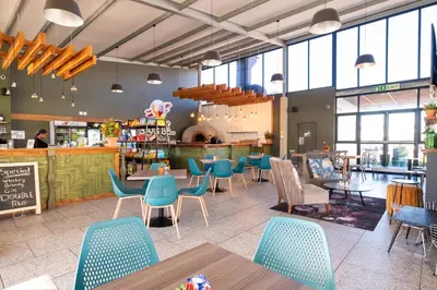 a restaurant with blue chairs and tables in a cafeteria at #AlimamaSpaces The Manson's Fynbos in Cape Town