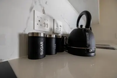 two black coffee mugs sitting on a kitchen counter at #AlimamaSpaces The Manson's Fynbos in Cape Town