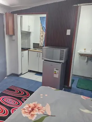 a small kitchen with a table with a flower on it at One Bed Room Apartment 1A in Cape Town