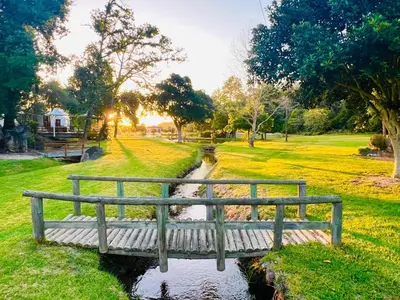 a bench sitting on a bridge in a park at Monkscowl Estate in Stellenbosch