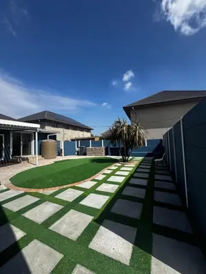 a garden with a lawn in front of a house at kitty guest house in Bellville