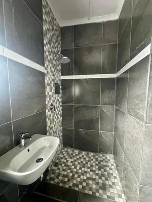 a bathroom with a sink and a tiled floor at kitty guest house in Bellville