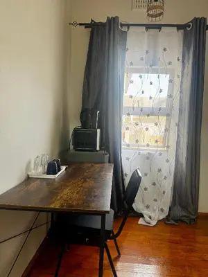 a room with a wooden table and a window at kitty guest house in Bellville