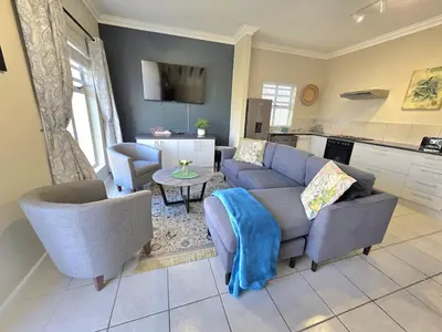a living room with a couch and chairs and a kitchen at 2 Bedroom house at Tweespruit - Pet friendly in Stellenbosch