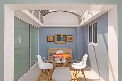 a dining room with a glass table and white chairs at The Woodbridge Hideaway in Cape Town