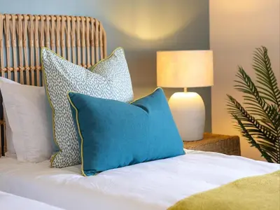 a bed with blue and white pillows on it at Cornercade | Unit 1 in Hermanus