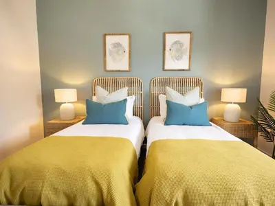 two beds sitting next to each other in a bedroom at Cornercade | Unit 1 in Hermanus