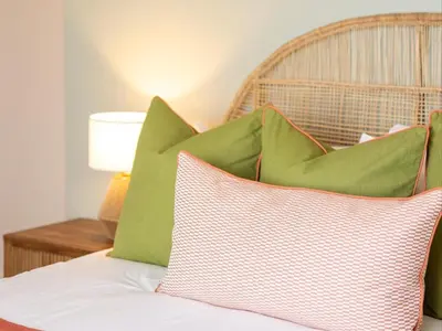 a pile of green pillows sitting on a bed at Cornercade | Unit 1 in Hermanus