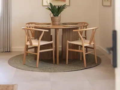 a wooden table with two chairs and a table with a plant at Cornercade | Unit 1 in Hermanus