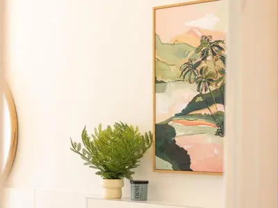 a plant sitting on a shelf next to a painting at Cornercade | Unit 1 in Hermanus