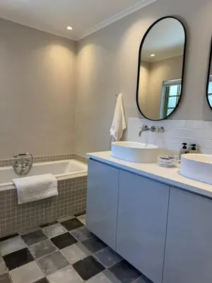 a bathroom with two sinks and a tub and a mirror at Pepler House in Franschhoek