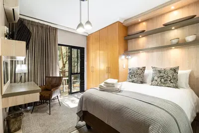 a bedroom with a bed and a desk and a chair at Avemore Eikehoff no 2 in Stellenbosch