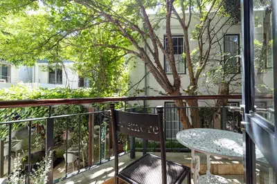a balcony with a table and a tree at Avemore Eikehoff no 2 in Stellenbosch