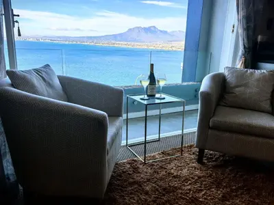 a living room with a couch and a table and a window at Boutique Inn - Quintessence in Gordonʼs Bay
