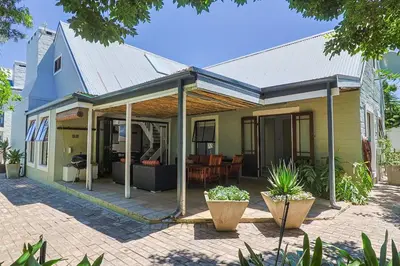 a house with a porch with a patio at Herringbone with Wood-Fired Hot Tub in Hermanus