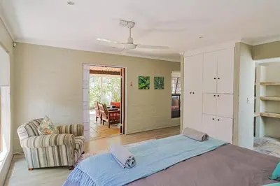 a bedroom with a bed and a living room at Herringbone with Wood-Fired Hot Tub in Hermanus