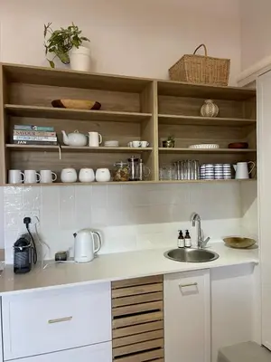 a kitchen with a sink and wooden shelves at Blou Huis in Hermanus