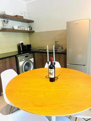 a bottle of wine on a wooden table in a kitchen at 144 Mayfair Discerning Luxury and Ultimate Comfort in Cape Town