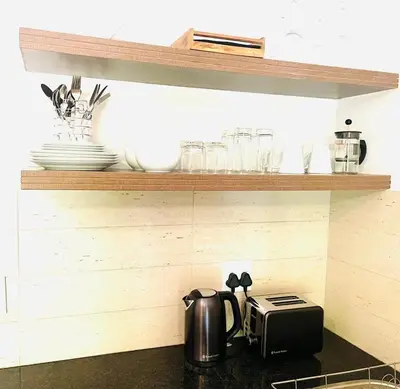 a kitchen counter with a toaster and plates on shelves at 144 Mayfair Discerning Luxury and Ultimate Comfort in Cape Town