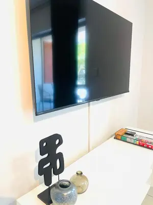 a flat screen tv on a wall above a counter at 144 Mayfair Discerning Luxury and Ultimate Comfort in Cape Town