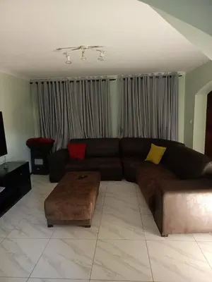 a living room with a brown couch and a table at Capetown Adilo Villa 2 in Cape Town