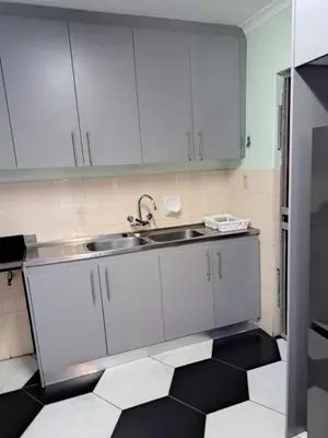 a kitchen with white cabinets and a sink at Capetown Adilo Villa 2 in Cape Town