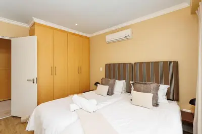 a bedroom with a large bed with white sheets and pillows at Pearl Valley Golf Estate, Cedar Point 4A in Simondium