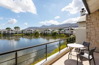 a balcony with a table and chairs and a view of a river at Pearl Valley Golf Estate, Cedar Point 4A in Simondium