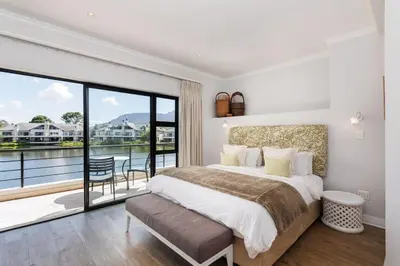 a bedroom with a large bed and a balcony at Pearl Valley Golf Estate, Cedar Point 4A in Simondium