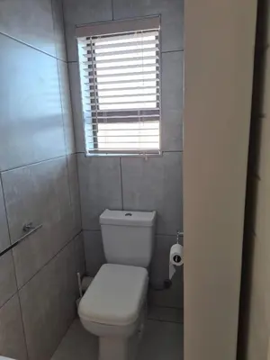 a small bathroom with a toilet and a window at Secure Modern stay at 41 on Kennington in Parklands