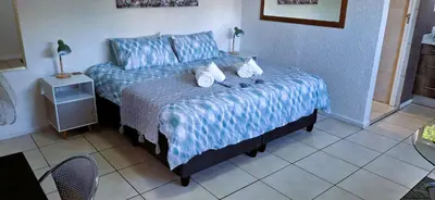 a bedroom with a bed with blue sheets and pillows at Cozy Quarters Self-Catering Accommodation in Bellville