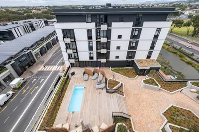 an overhead view of a building with a patio and a pool at 827 Riverlands - Studio Apartment with Parking in Cape Town