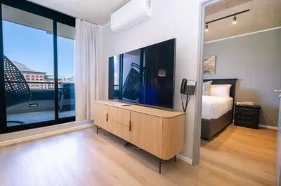 a bedroom with a large television and a bed at 312 Riverlands - Lux 2 bedroom Apartment in Cape Town