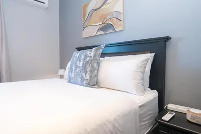 a bedroom with a white bed with a black headboard at 312 Riverlands - Lux 2 bedroom Apartment in Cape Town