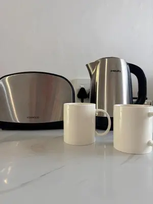 two coffee cups on a counter next to a toaster at Le Grec Wine Tram Apartment #2 in Franschhoek
