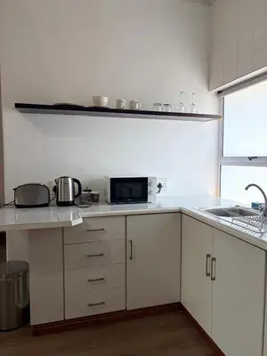 a kitchen with white cabinets and a counter top at Le Grec Wine Tram Apartment #2 in Franschhoek