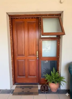 a wooden door with a potted plant in front of it at Le Grec Wine Tram Apartment #2 in Franschhoek