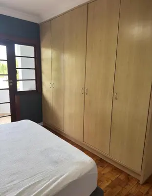 a bedroom with wooden cabinets and a white bed at The Botanic Venus in Paarl